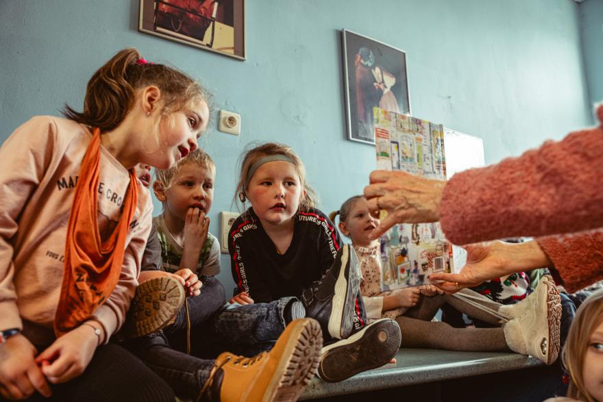 een Leesjury-begeleider toont een boek aan de juryleden 