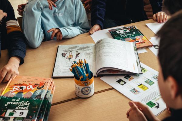 Juryleden van een Leesjury-groep op school zitten rond de tafel