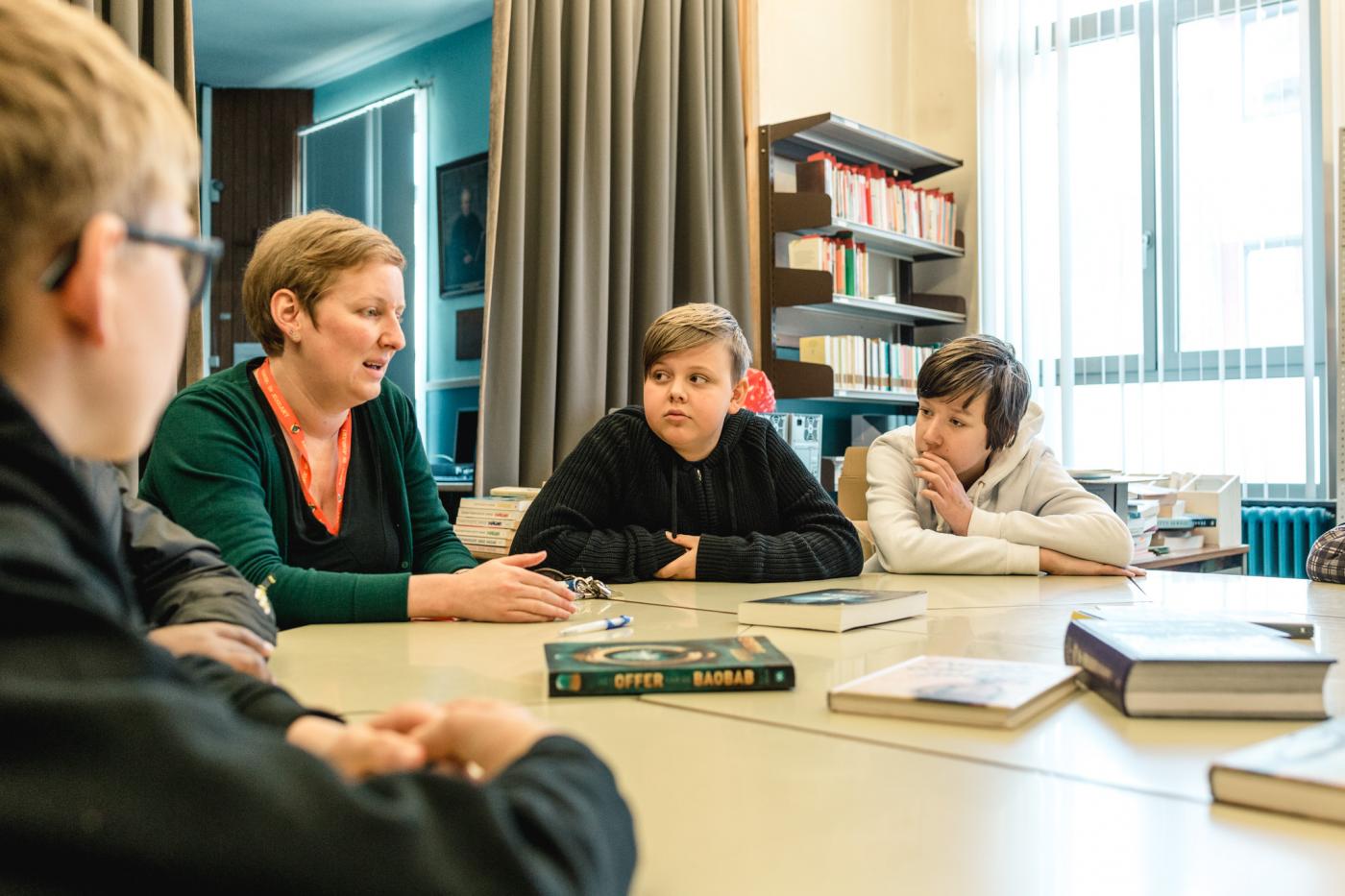 begeleider praat met juryleden over boeken