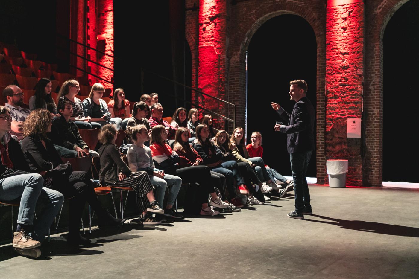 Presentator met zaal vol juryleden