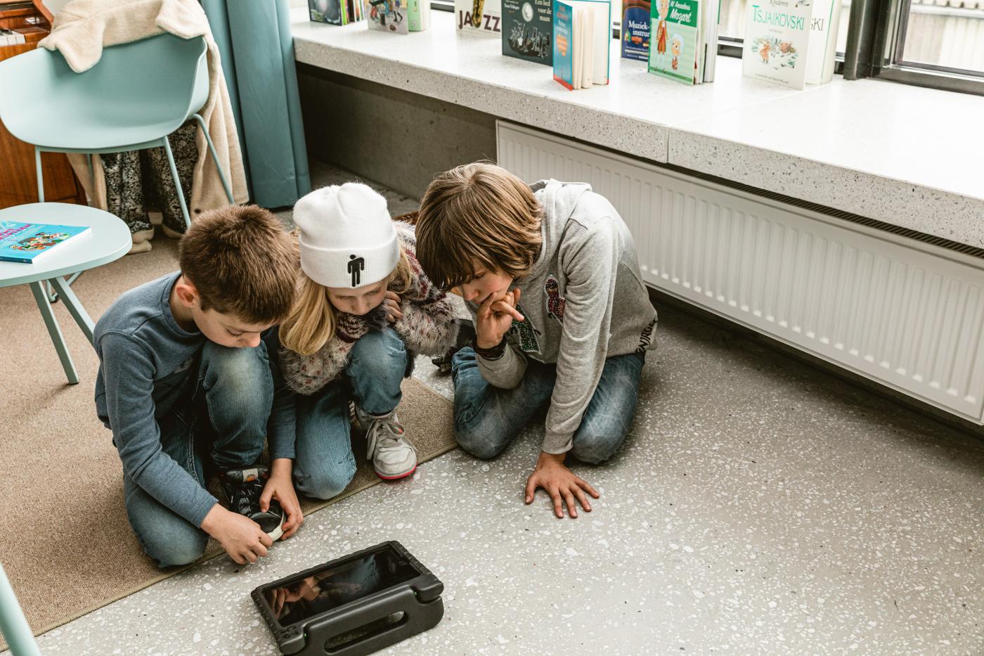 kinderen kijken samen naar een tablet