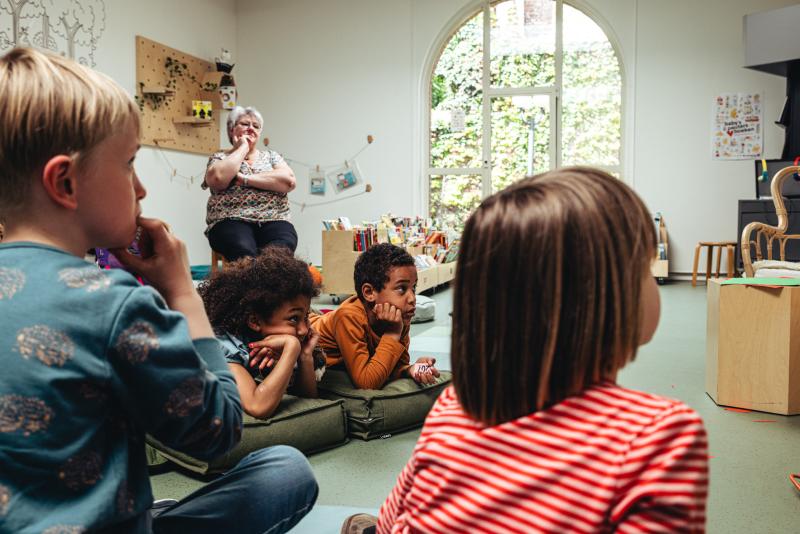 kinderen luisteren naar een auteurslezing