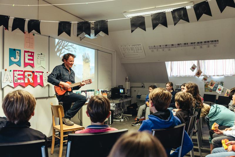 auteur Jef Aerts speelt gitaar op het Leesjury-feest in Holsbeek