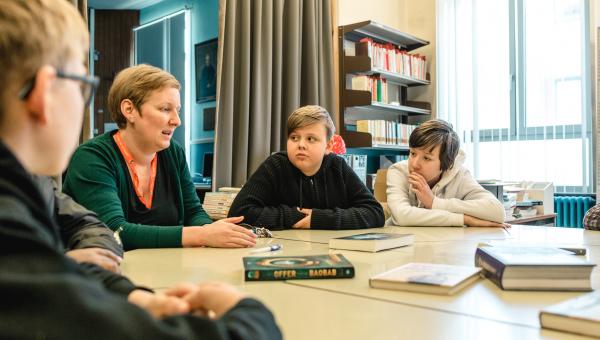 begeleider praat met juryleden over boeken