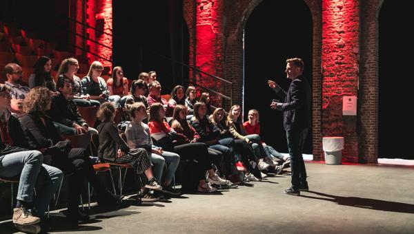 Presentator met zaal vol juryleden